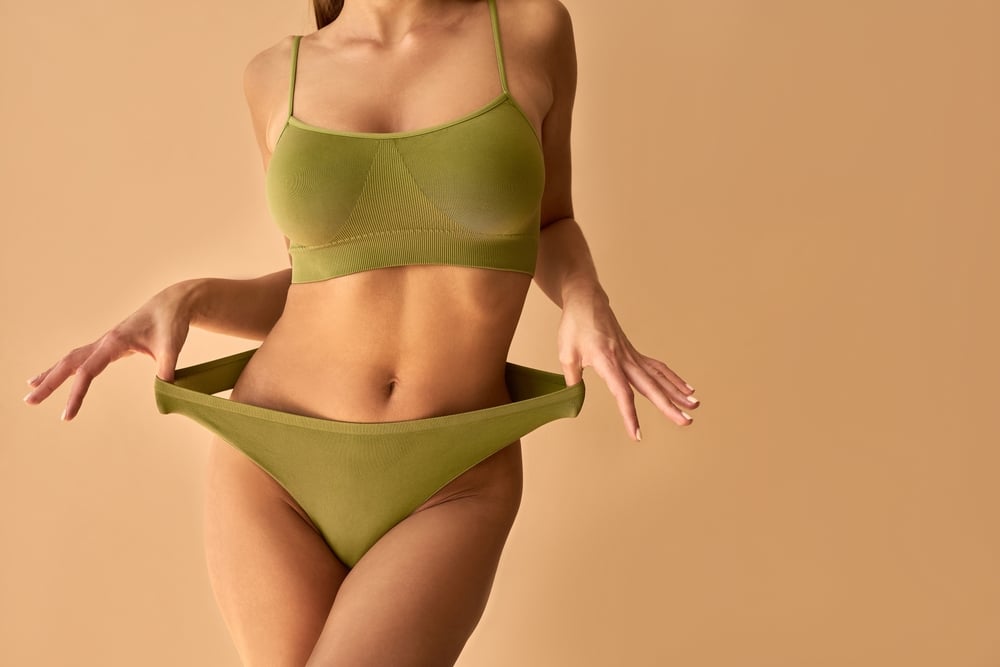 A,Sporty,Tanned,Woman,In,Green,Underwear,Poses,On,A